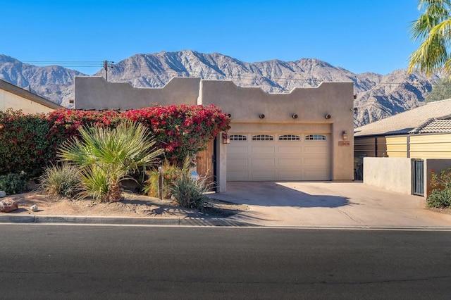 adobe home with a mountain view and a garage