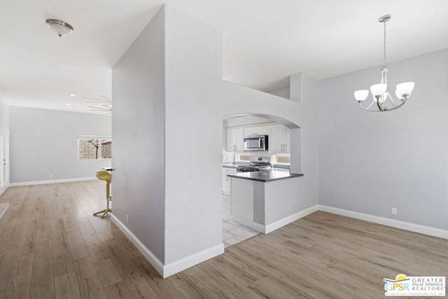 interior space featuring light wood-type flooring and an inviting chandelier