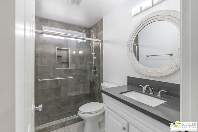 bathroom with toilet, a shower with door, and vanity