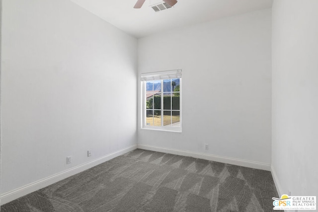 spare room featuring ceiling fan and dark carpet