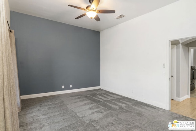 carpeted spare room with washer / dryer and ceiling fan