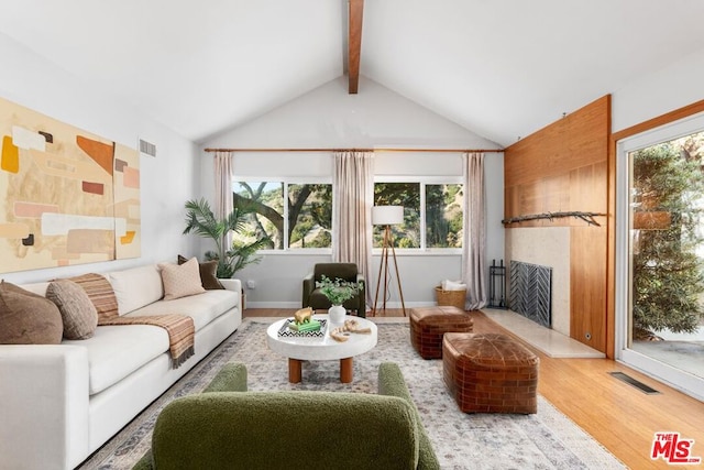 living room featuring vaulted ceiling with beams and wood-type flooring