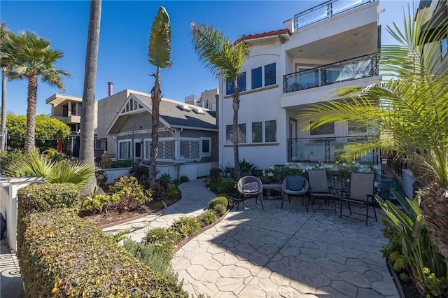 back of house featuring a balcony and a patio