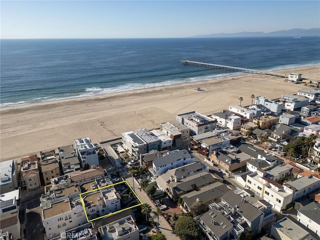 drone / aerial view featuring a beach view and a water view