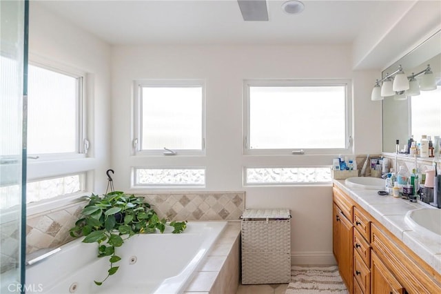 bathroom featuring vanity and a relaxing tiled tub