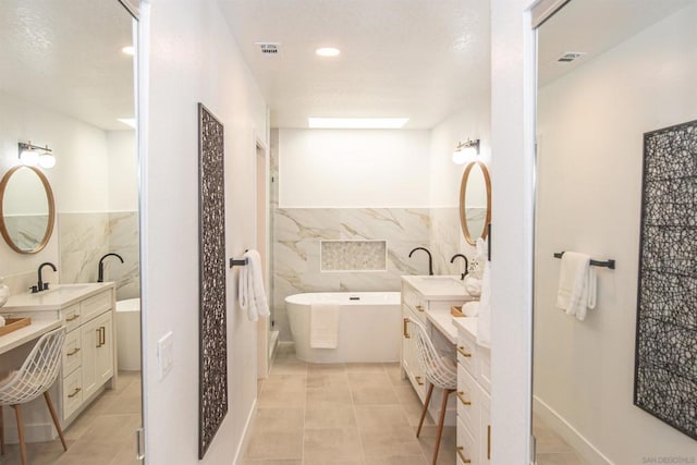 bathroom featuring tile walls, vanity, and a tub