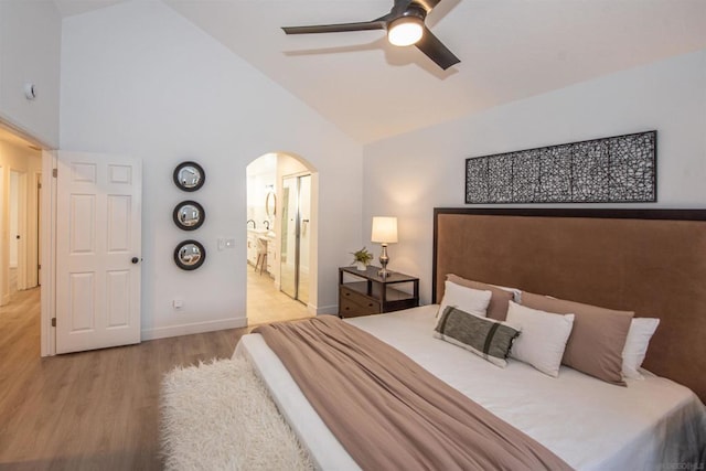 bedroom featuring high vaulted ceiling, connected bathroom, ceiling fan, and light hardwood / wood-style flooring