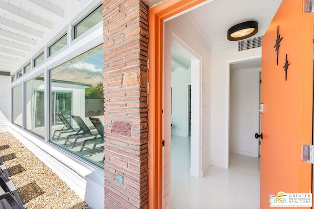 corridor with floor to ceiling windows and beam ceiling