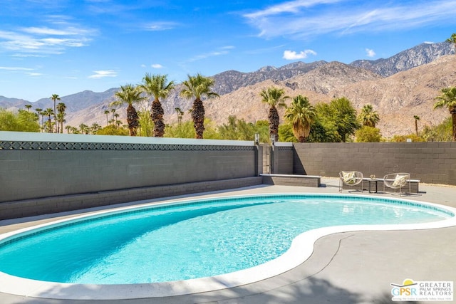 view of swimming pool with a mountain view and a patio area