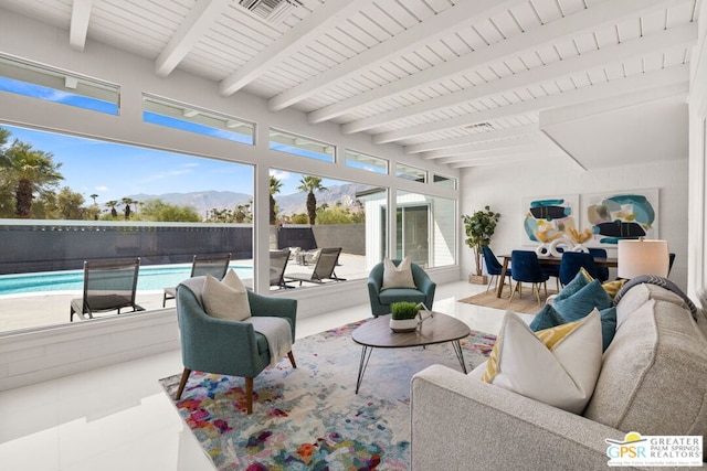 sunroom with beamed ceiling and a mountain view