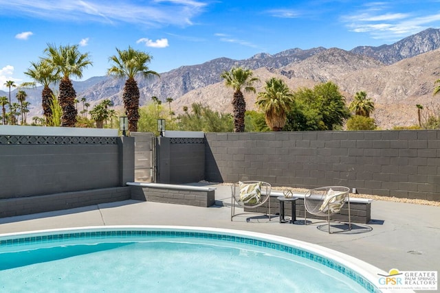 view of swimming pool with a mountain view and a patio area