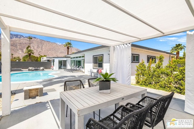 view of patio / terrace featuring a fenced in pool and a mountain view