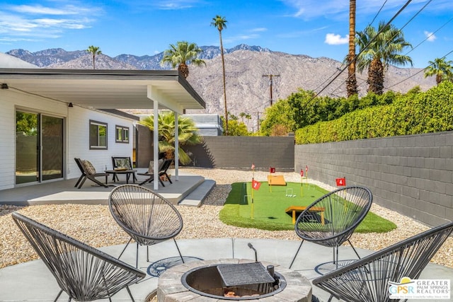 view of patio / terrace with a mountain view and a fire pit