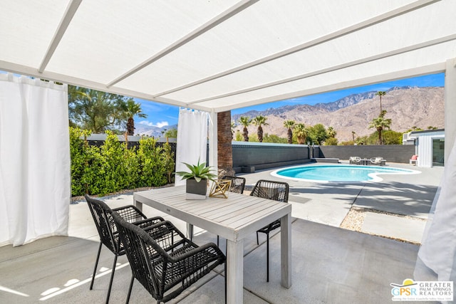 view of swimming pool with a mountain view and a patio area