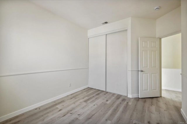 unfurnished bedroom featuring light wood-type flooring and a closet