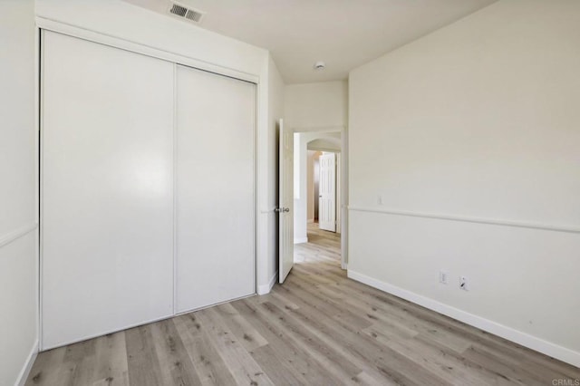 unfurnished bedroom with light wood-type flooring and a closet