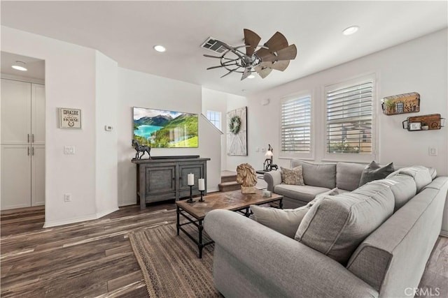 living room featuring dark wood-type flooring and ceiling fan