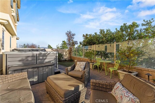 balcony featuring a hot tub, an outdoor hangout area, and a patio