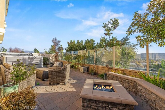 view of patio / terrace with an outdoor living space with a fire pit and a mountain view