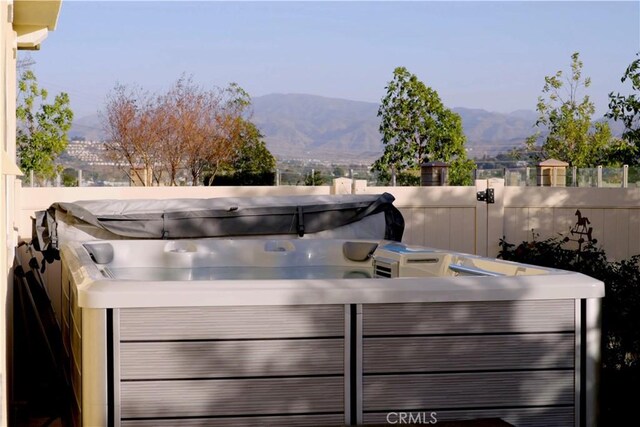 view of patio with a mountain view and a hot tub