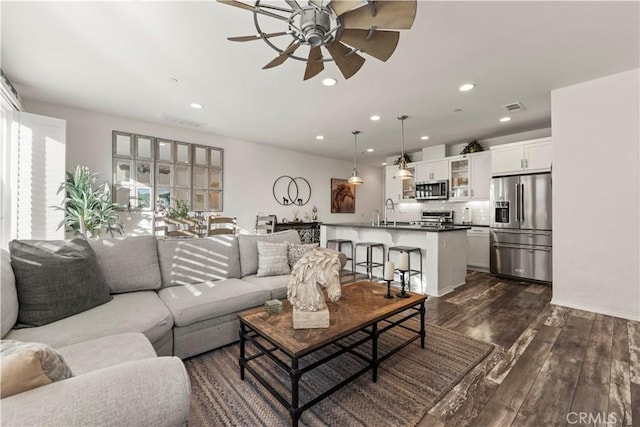 living room with ceiling fan, dark hardwood / wood-style floors, and sink