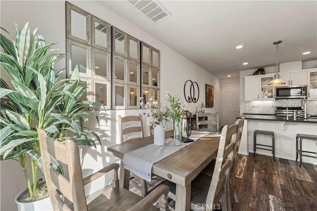 dining area featuring dark wood-type flooring and sink