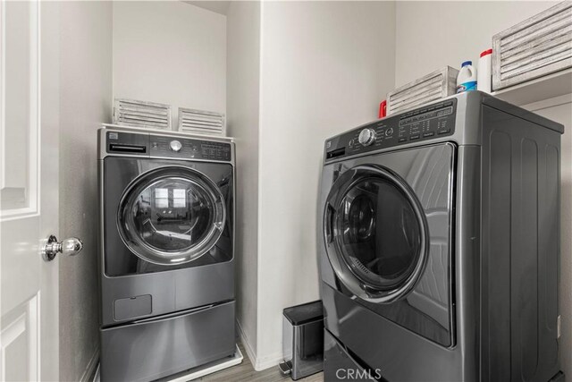 washroom featuring independent washer and dryer and wood-type flooring