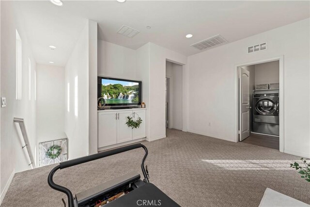 exercise room featuring washer / clothes dryer and carpet flooring