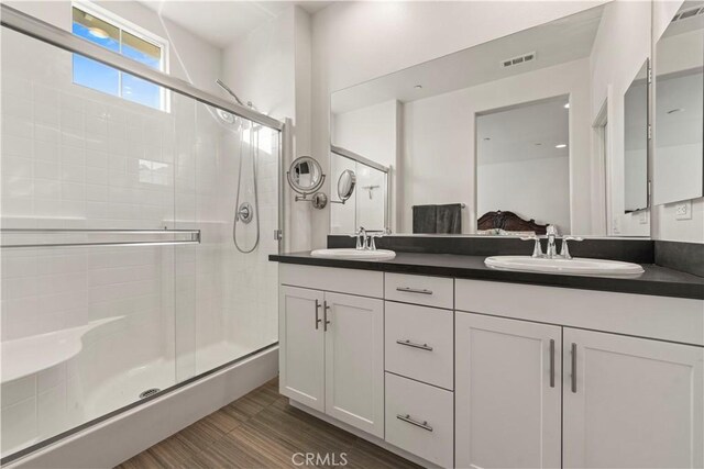 bathroom with walk in shower and vanity