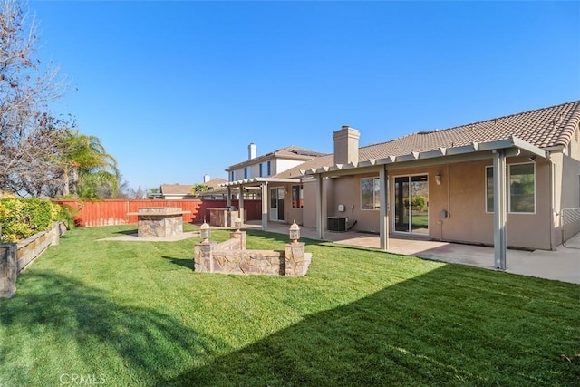 rear view of house featuring a patio, central AC, and a lawn