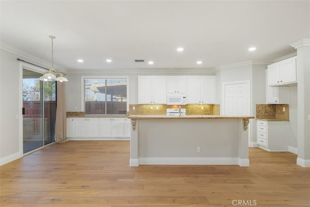 kitchen featuring white cabinetry, crown molding, and hanging light fixtures