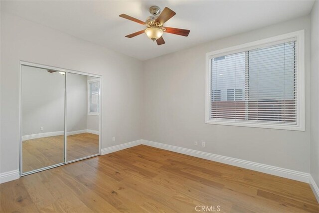 unfurnished bedroom featuring a closet, ceiling fan, and light wood-type flooring