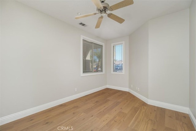 empty room with ceiling fan and light hardwood / wood-style flooring