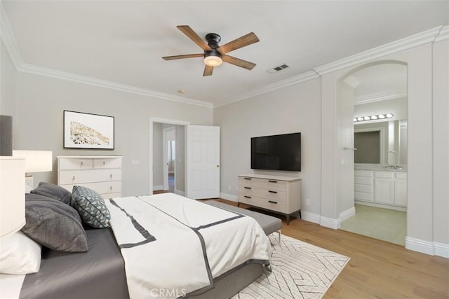 bedroom featuring ceiling fan, ornamental molding, ensuite bath, and light hardwood / wood-style floors