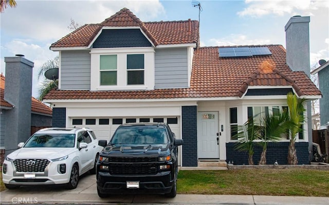 view of front facade featuring a front yard, solar panels, and a garage