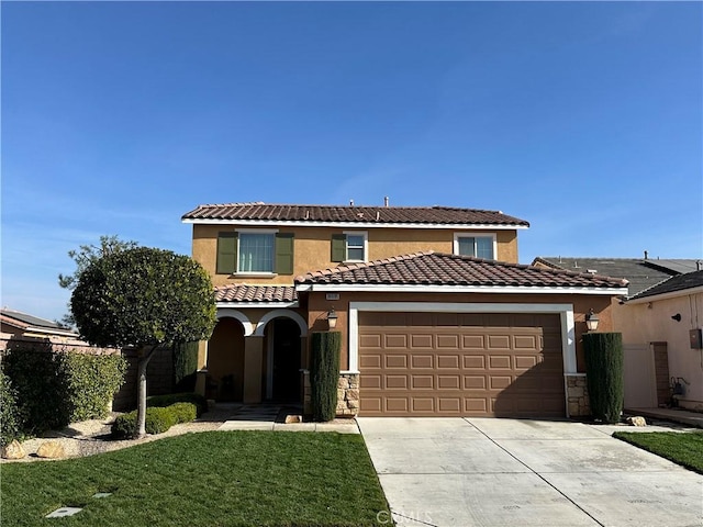 mediterranean / spanish-style house featuring a garage and a front lawn