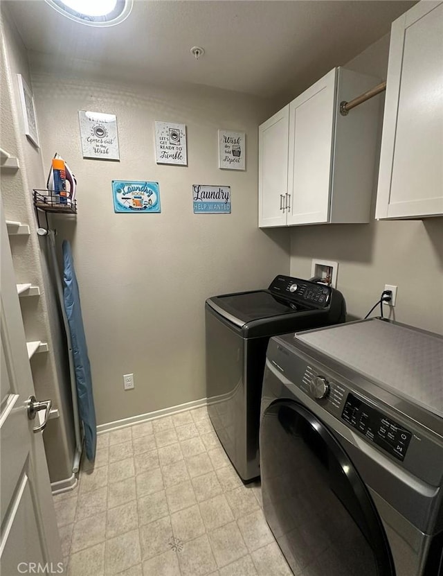 clothes washing area with cabinets and separate washer and dryer