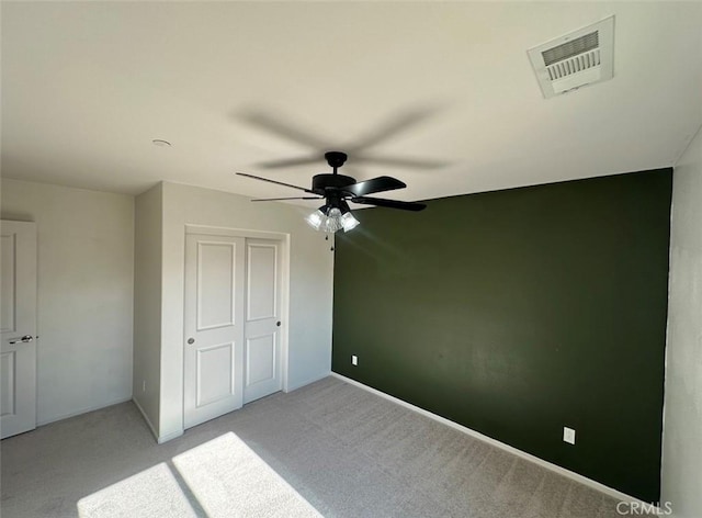 unfurnished bedroom with light carpet, a closet, and ceiling fan