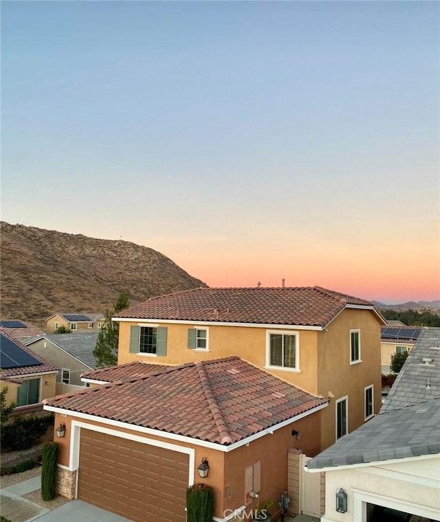 view of front of home with a mountain view and a garage