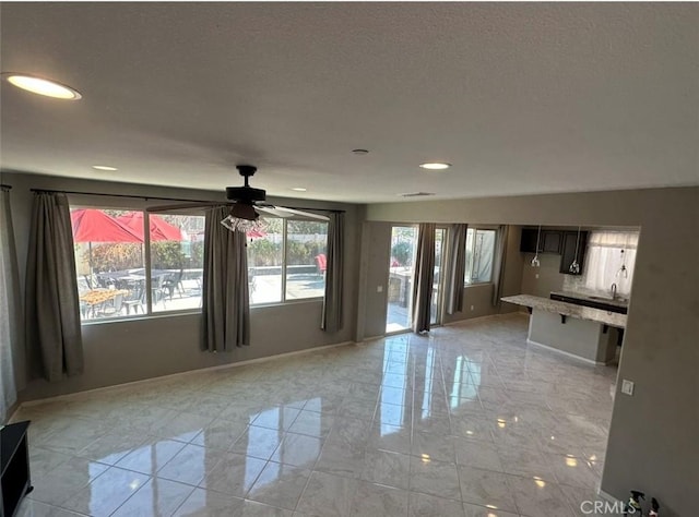 unfurnished living room with ceiling fan