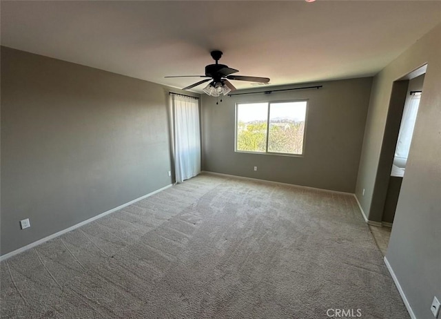 spare room featuring light colored carpet and ceiling fan