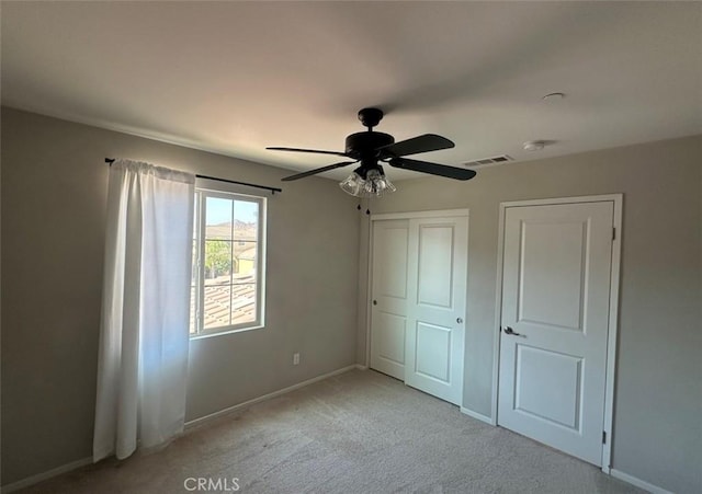 unfurnished bedroom featuring light colored carpet and ceiling fan