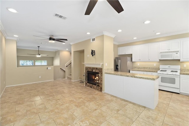 kitchen featuring white cabinets, light stone countertops, white appliances, and a fireplace