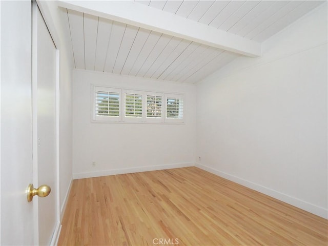 unfurnished room with vaulted ceiling with beams and wood-type flooring