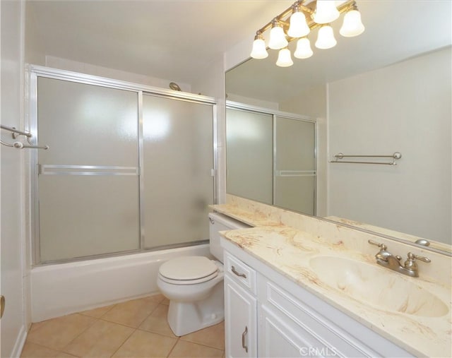 full bathroom featuring tile patterned floors, enclosed tub / shower combo, vanity, and toilet