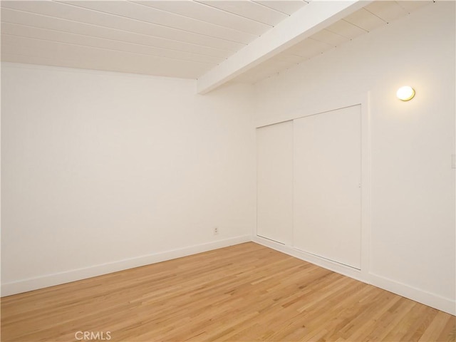 unfurnished room featuring wooden ceiling, beam ceiling, and hardwood / wood-style flooring