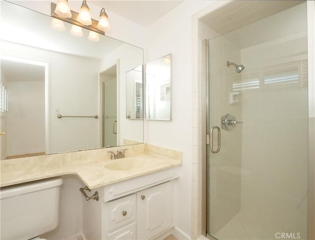 bathroom with an enclosed shower, vanity, and toilet