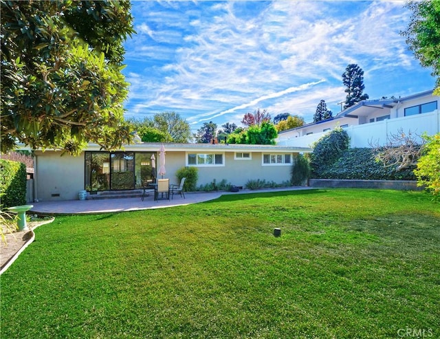 rear view of house with a patio area and a lawn