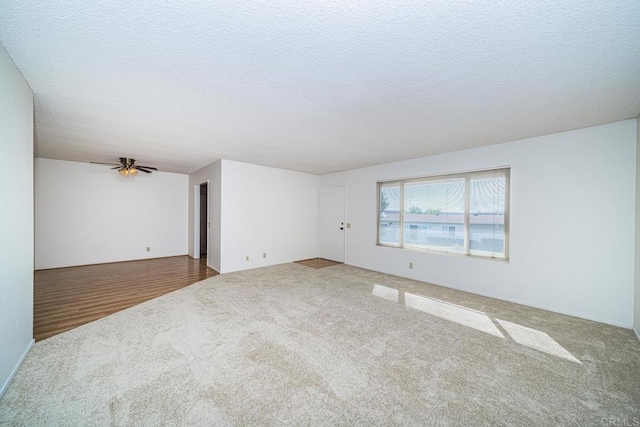 empty room featuring ceiling fan, a textured ceiling, and carpet flooring