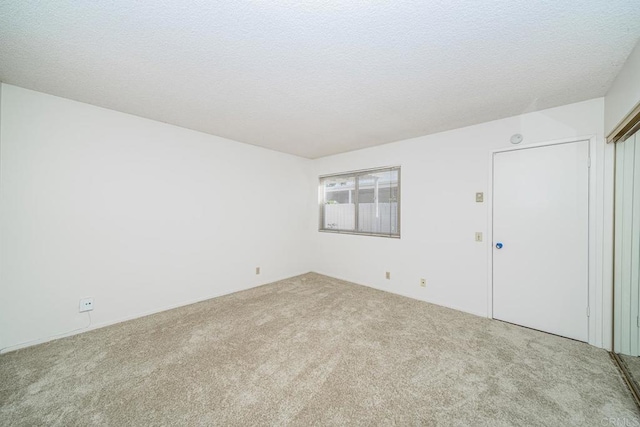 spare room with a textured ceiling and carpet flooring